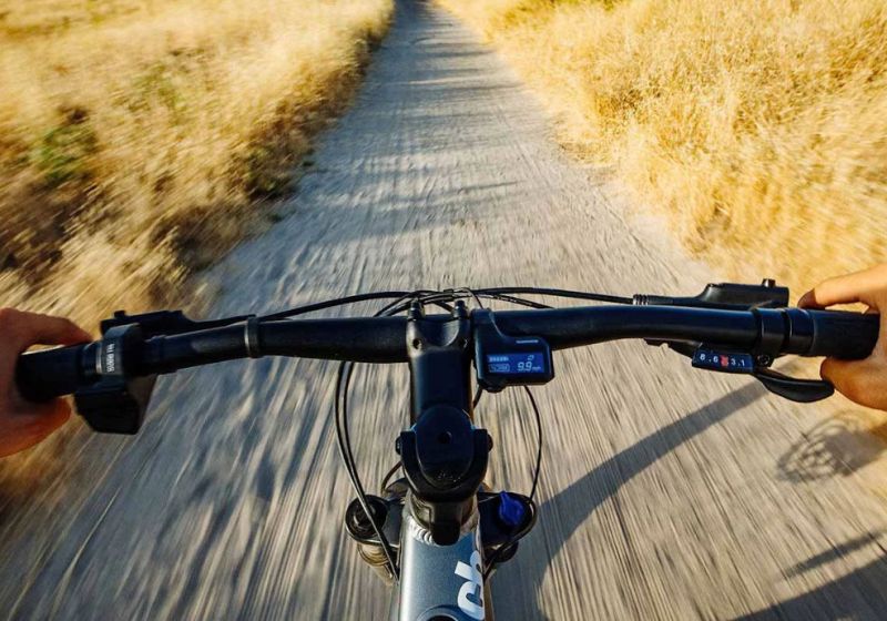 A point-of-view angle of a bike riding down a dirt path.